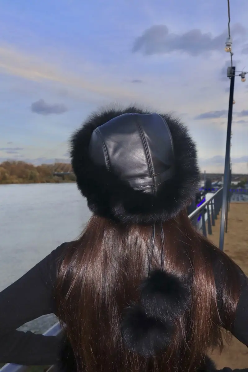 Fur hat seen from behind, river at dusk