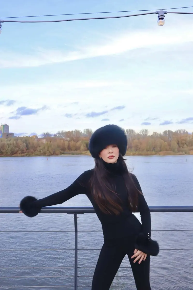 Standing by the river in a black fur hat